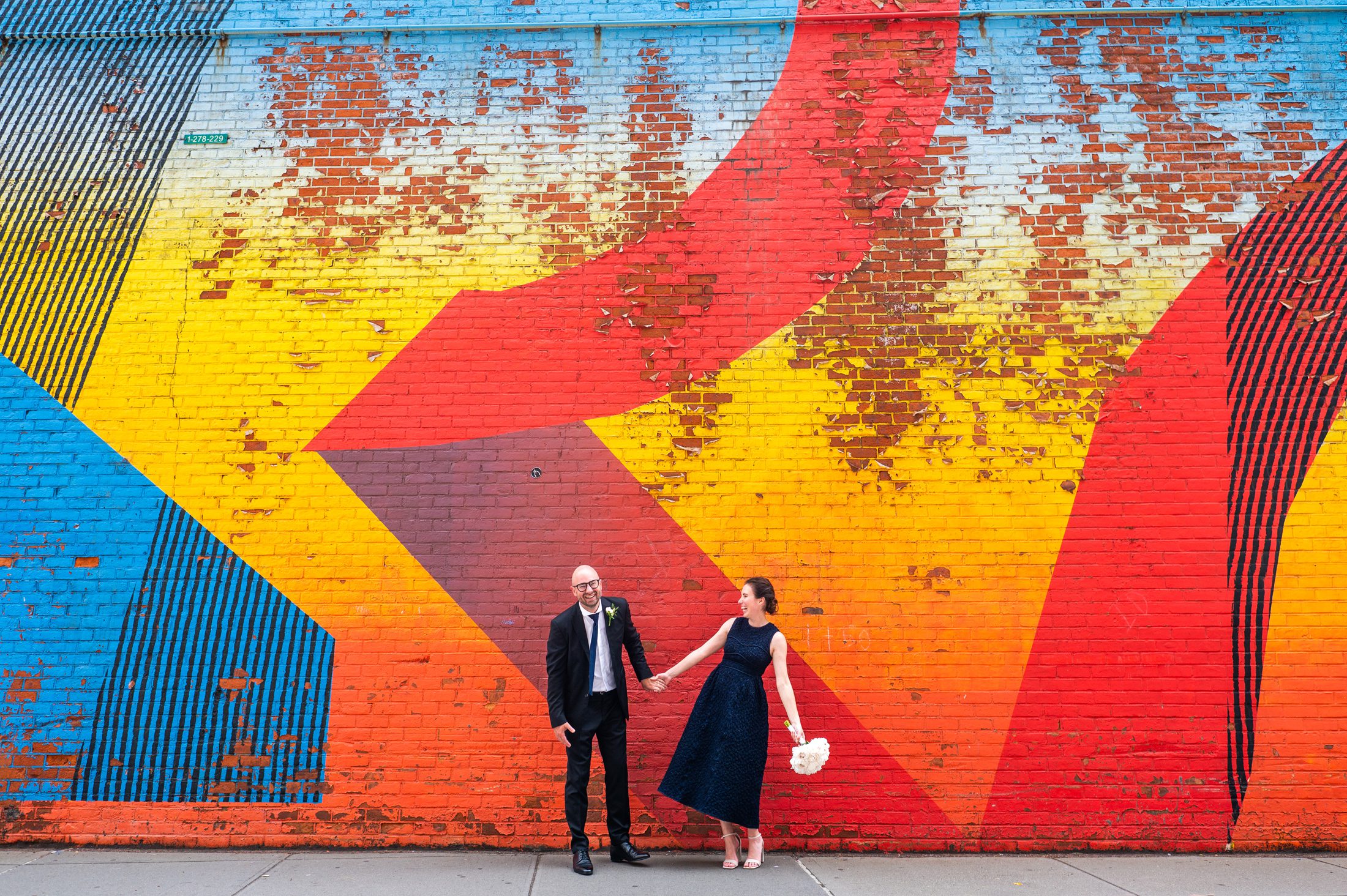 Couple in front of a colorful graffi