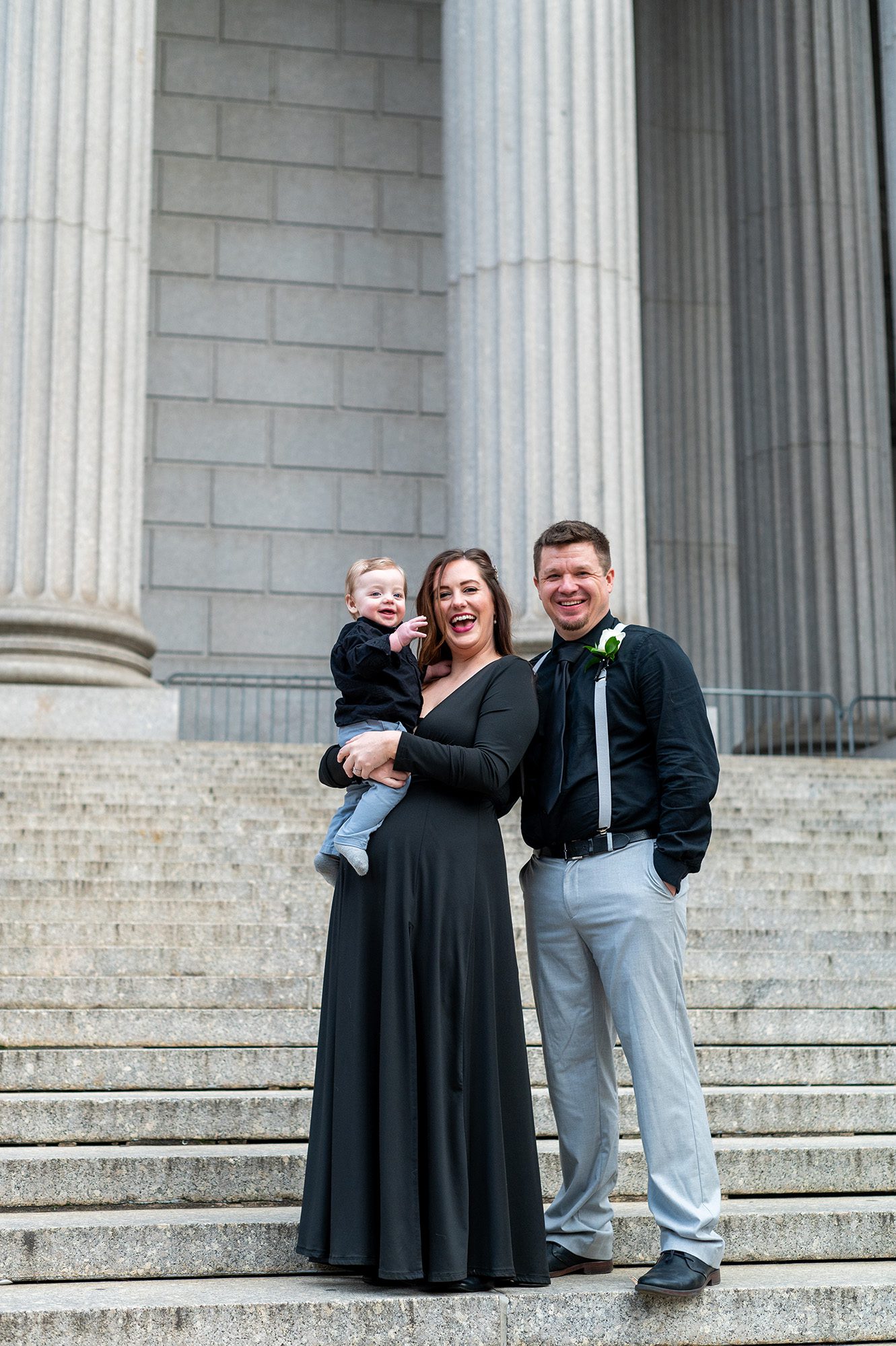 A bride and groom with their baby after their city hall elopement in NYC