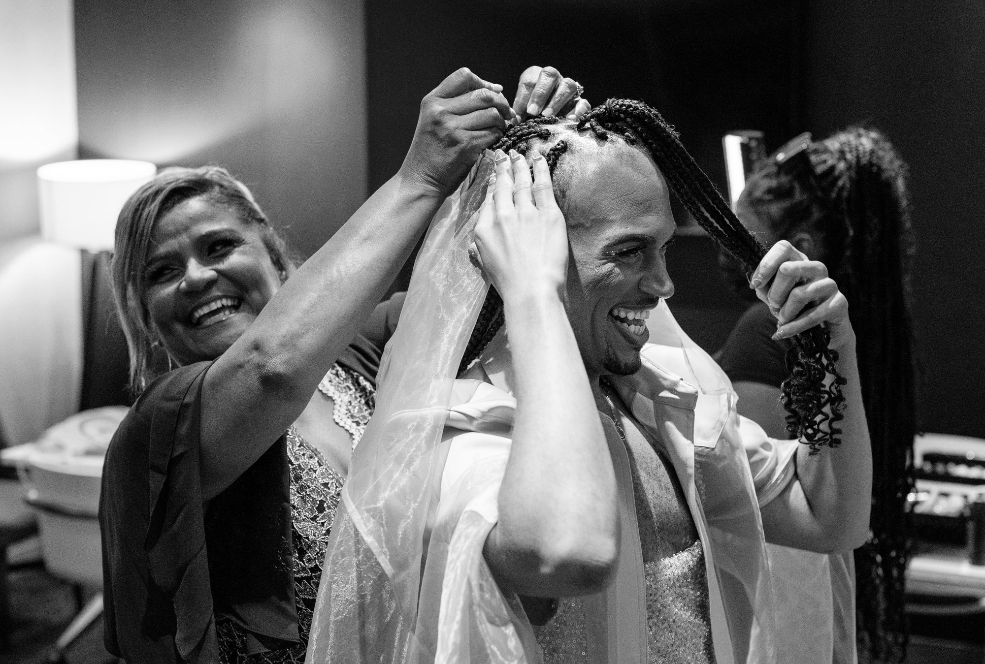 Black and white photo of a mom helping her son with his hair on a wedding day. 