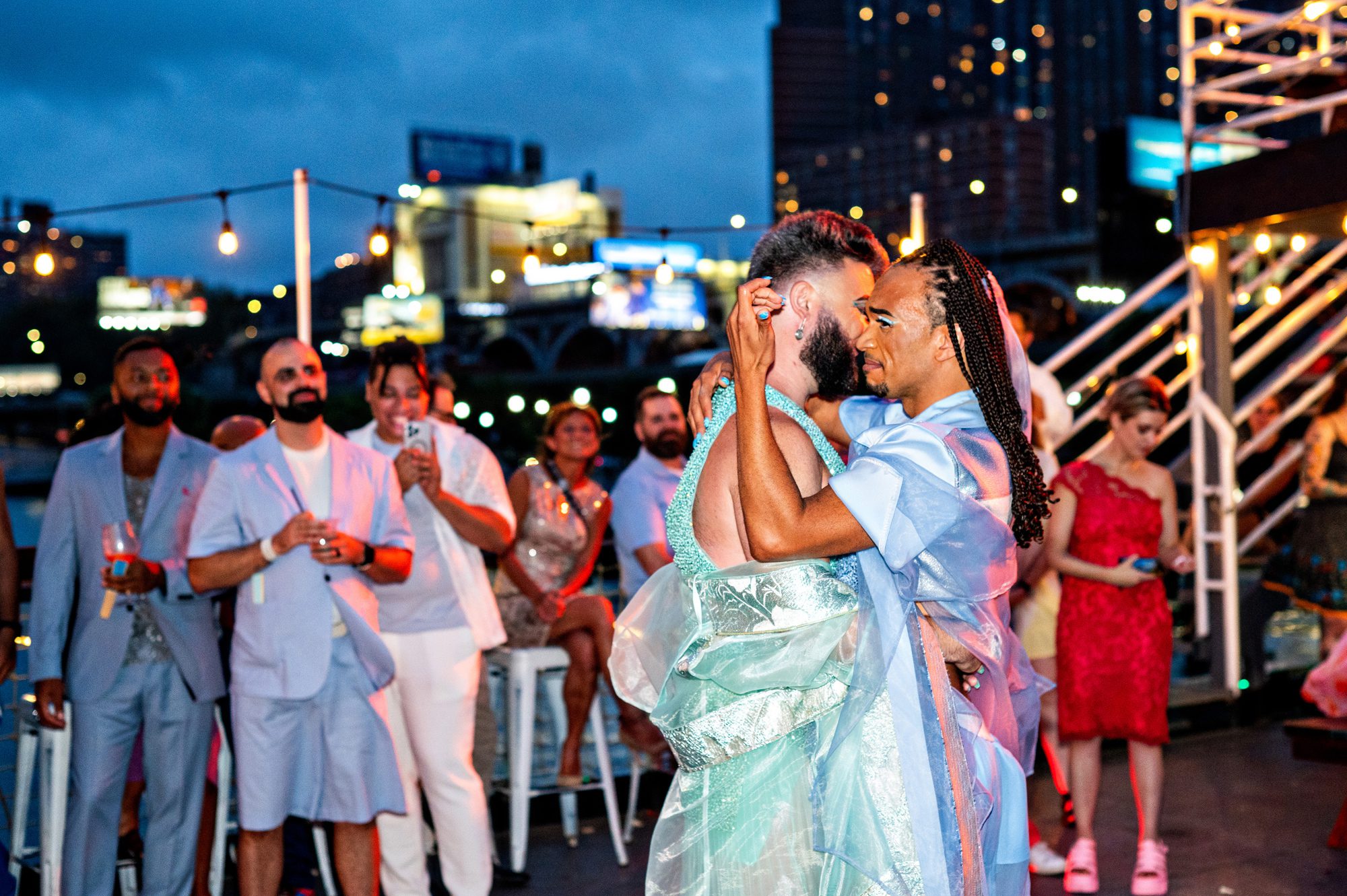 A queer couple embracing during their first dance. 