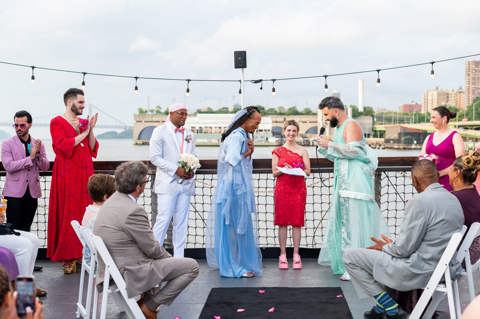 A couple exchanging vows during their wedding ceremony on a boat docked in Harlem the Baylander. 