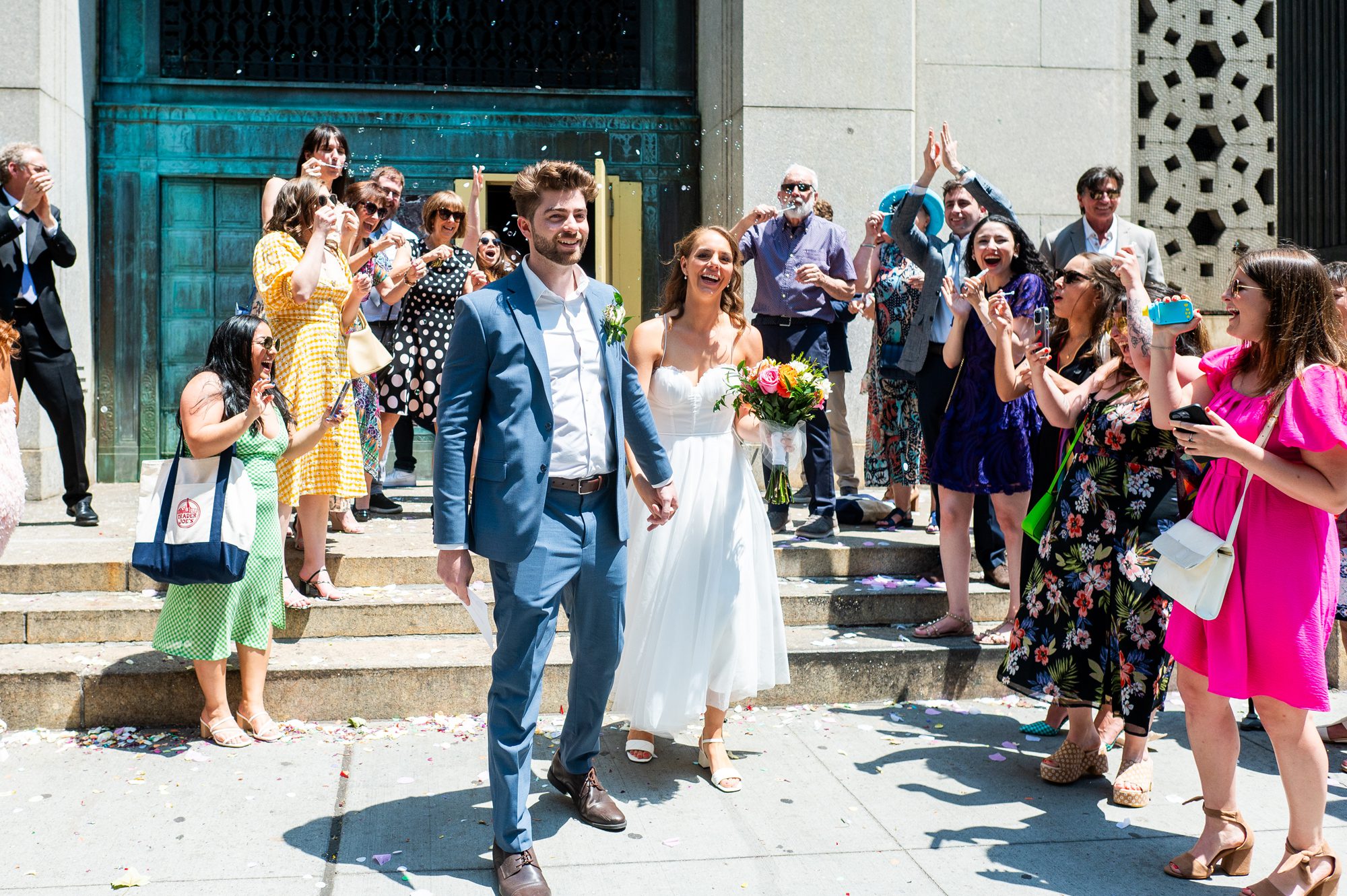 A couple exiting City Hall with lots of confetti after their NYC City Hall Elopement.  
