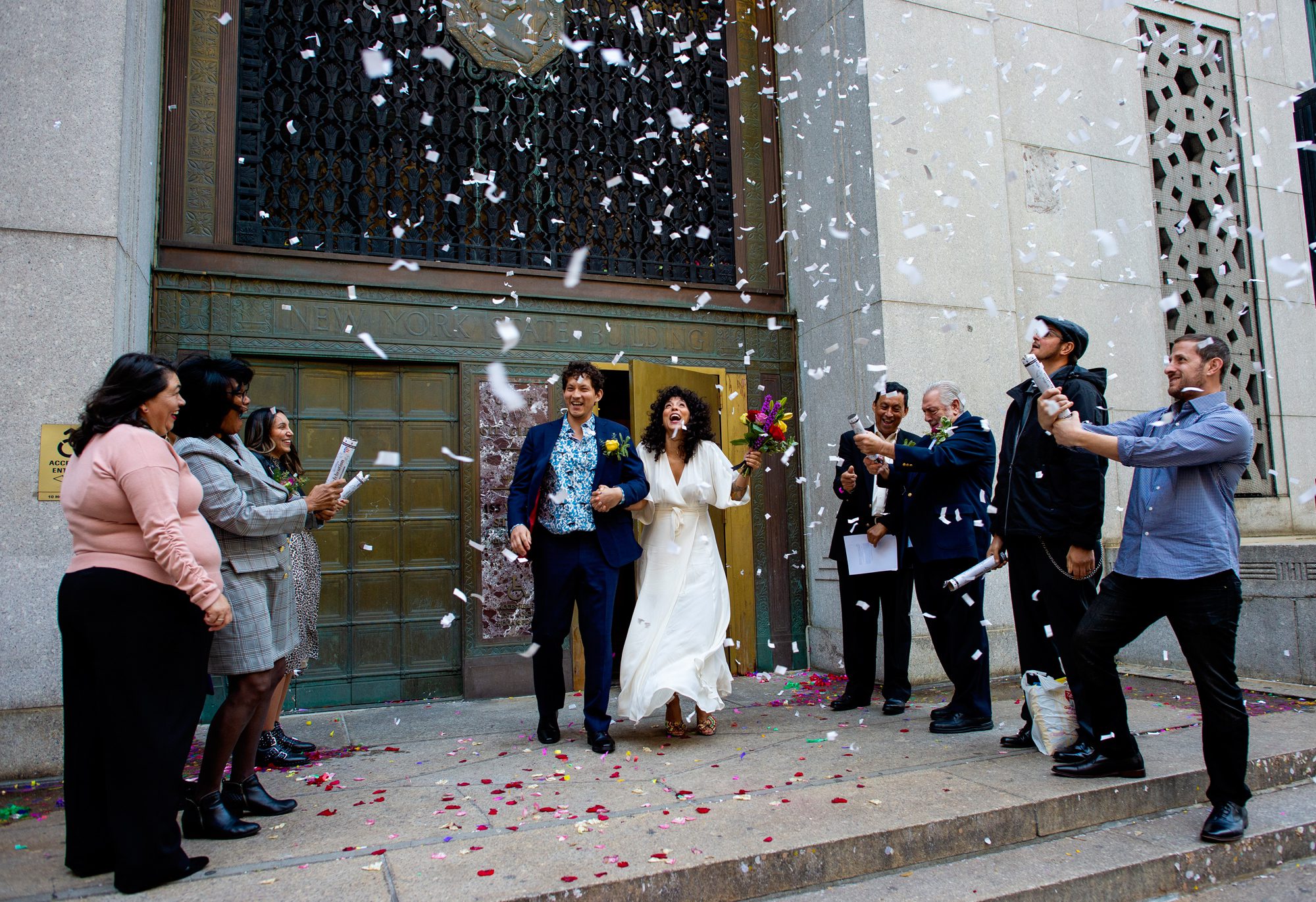 Bride and Groom exiting City Hall in NYC after their City Hall Wedding with a lot of confetti. 