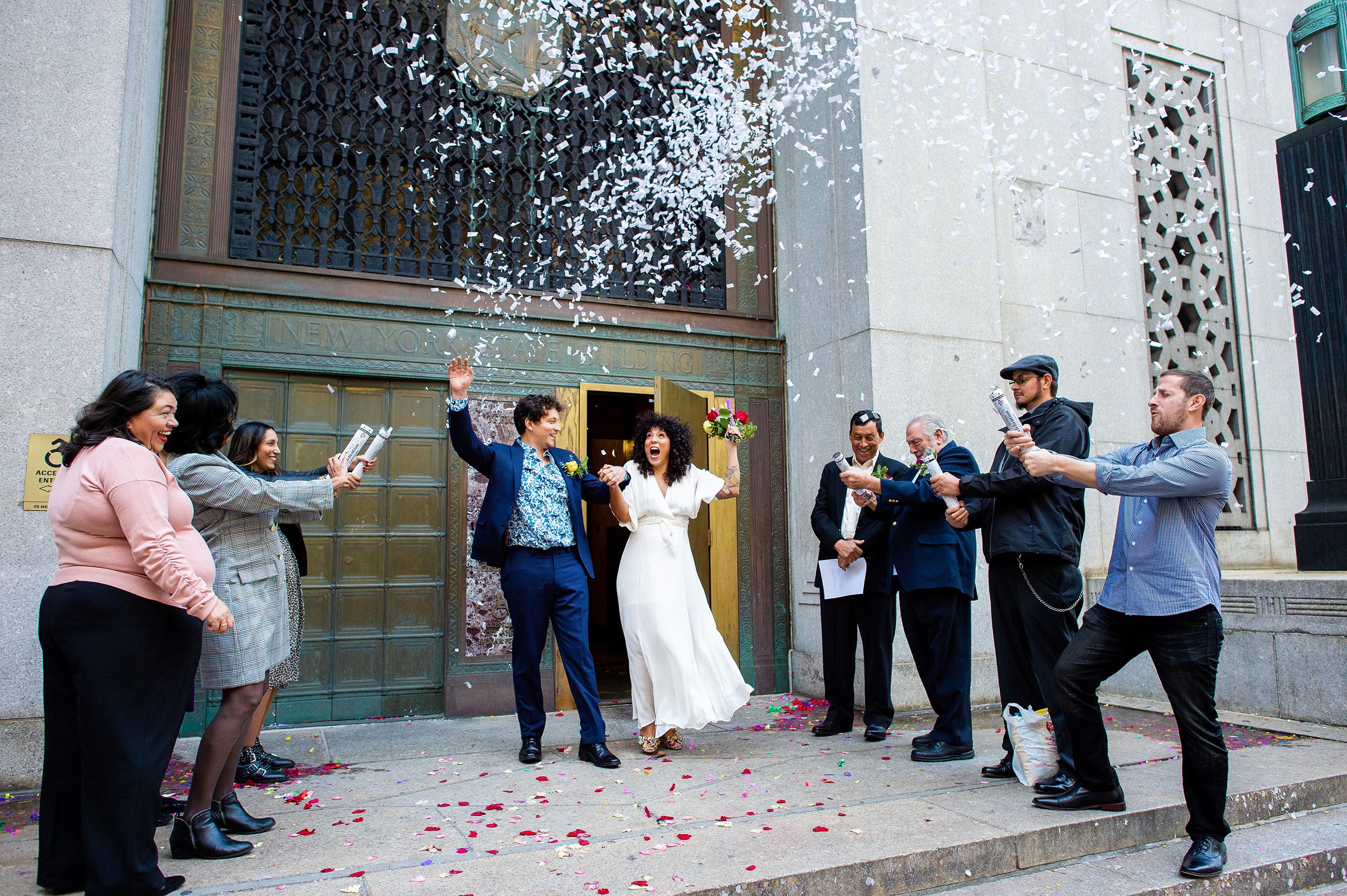 Couple exiting City Hall with a confeti pop.