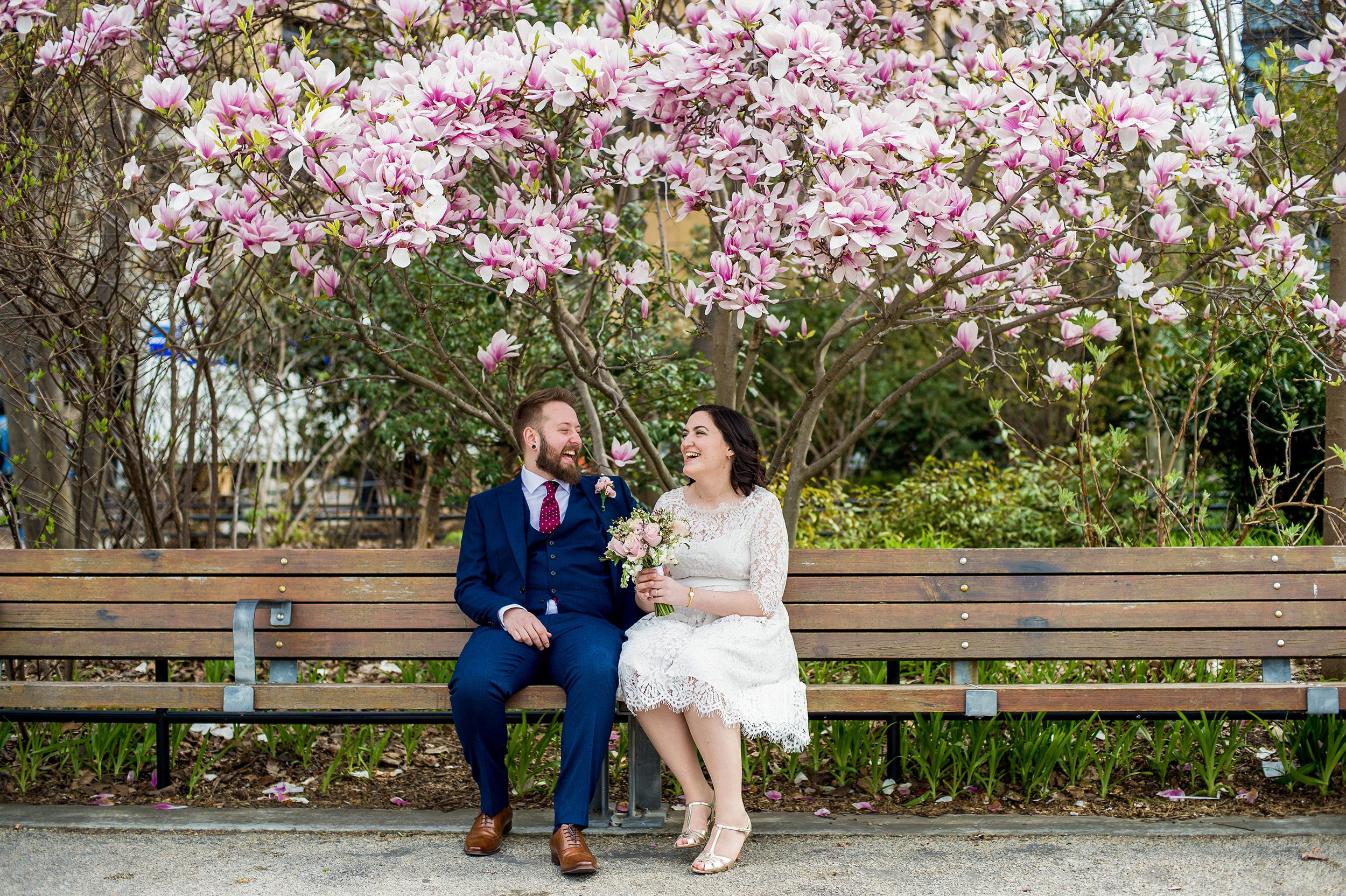 Couple laughing under magnolia tree in Brooklyn 
