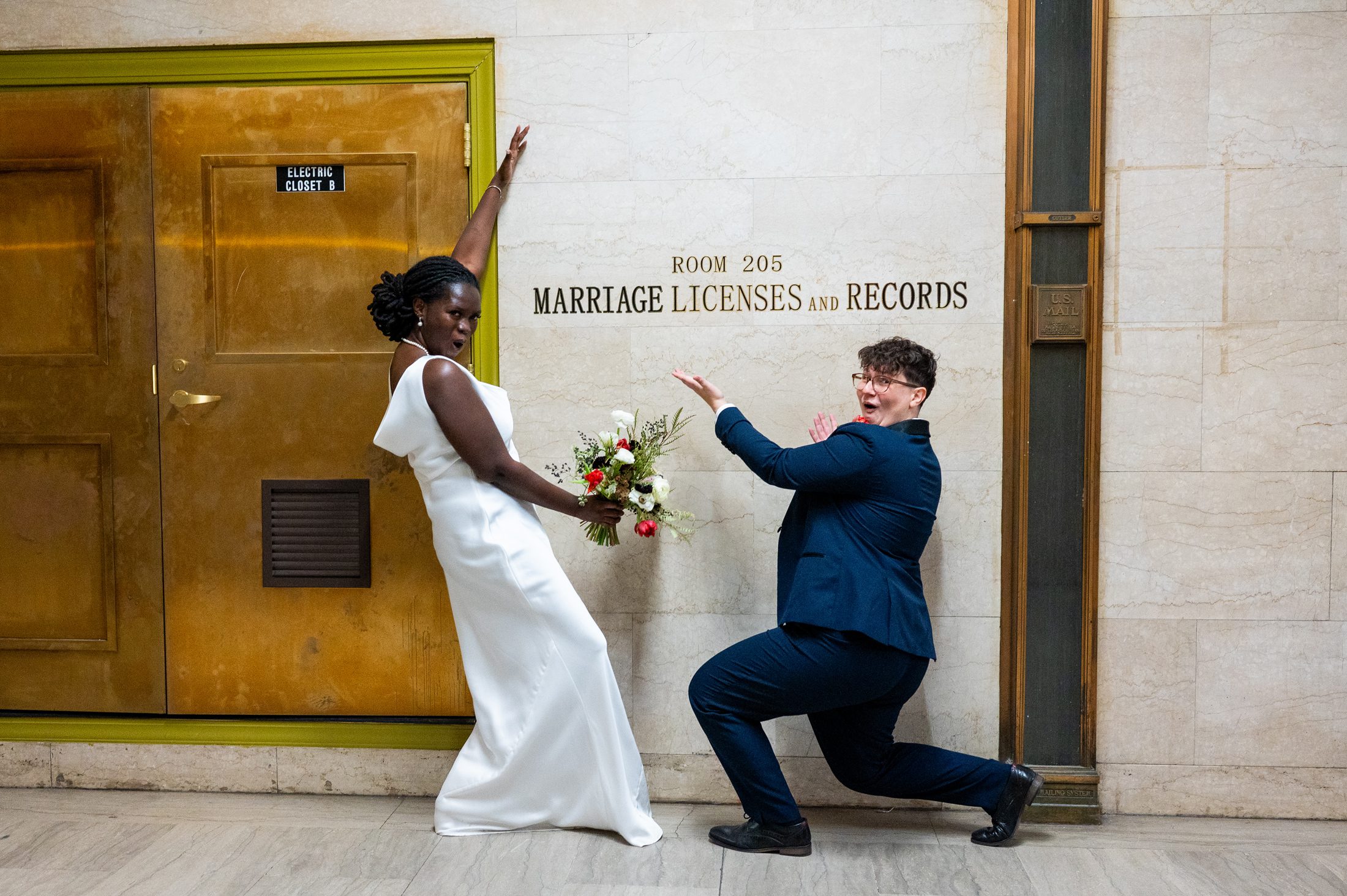 Queer couple posing outside the Brooklyn City Clerk's Office after getting married