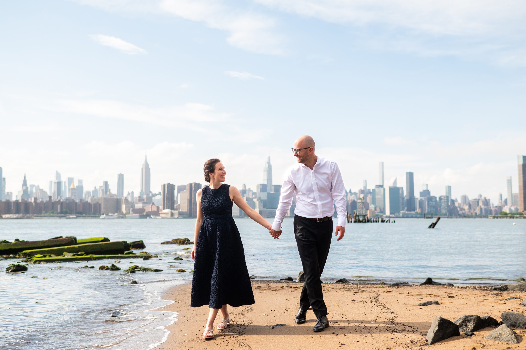 Bride and Groom on the beach in Brooklyn with the NYC Skyline behind them. 