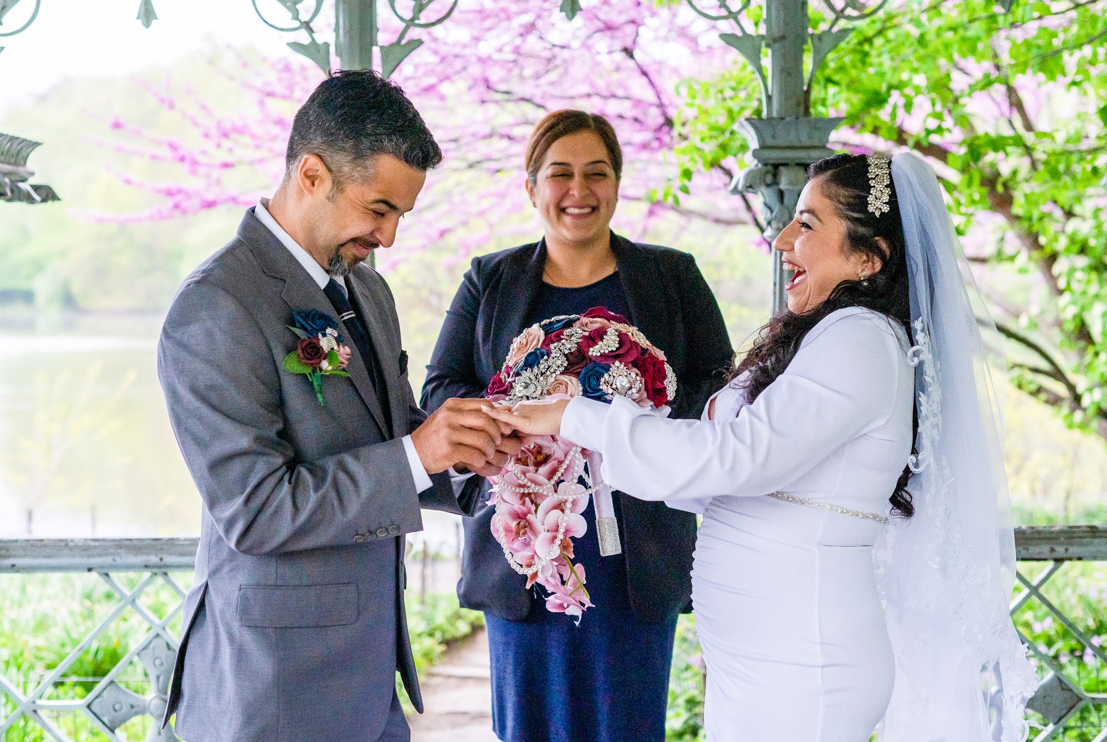 Couple exchanges rings during their spring wedding ceremony at Ladies Pavilion in Central Park 