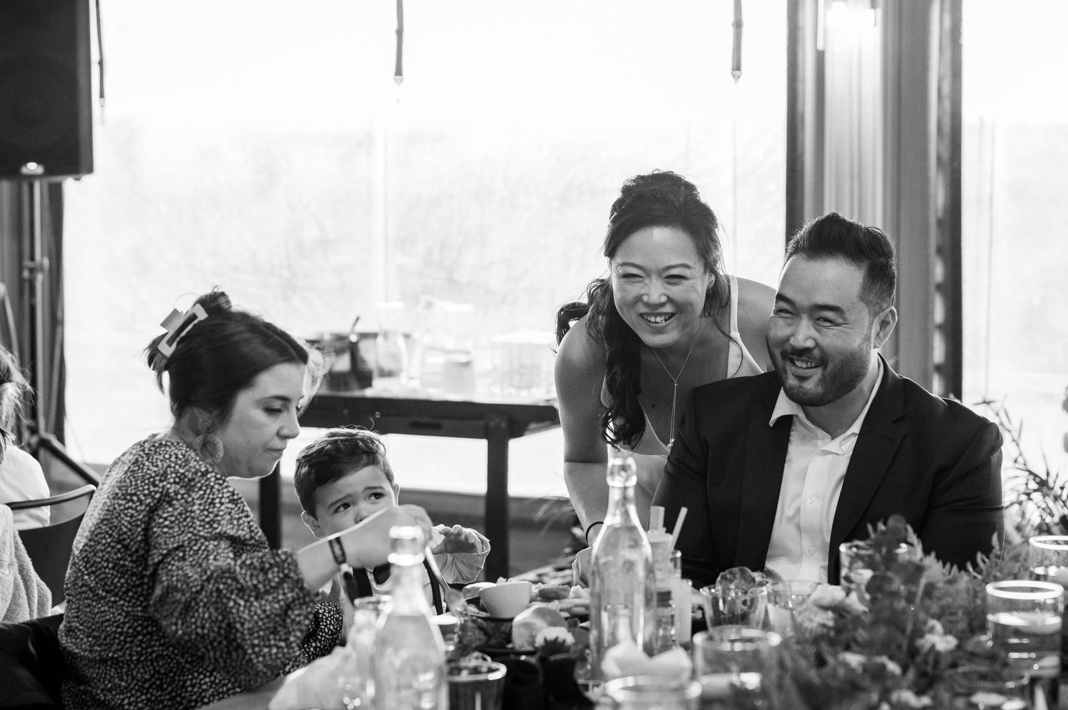 Black and white image of bride with family at wedding reception in tent at Collective Retreats 
