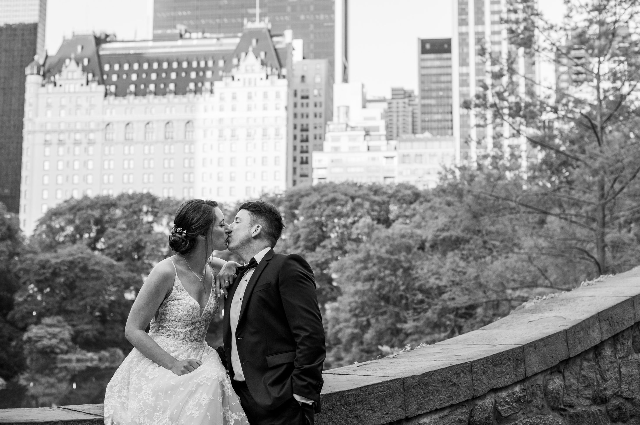 Black and white photo of bride and groom kissing on Gapstow Bridge in Central Park 