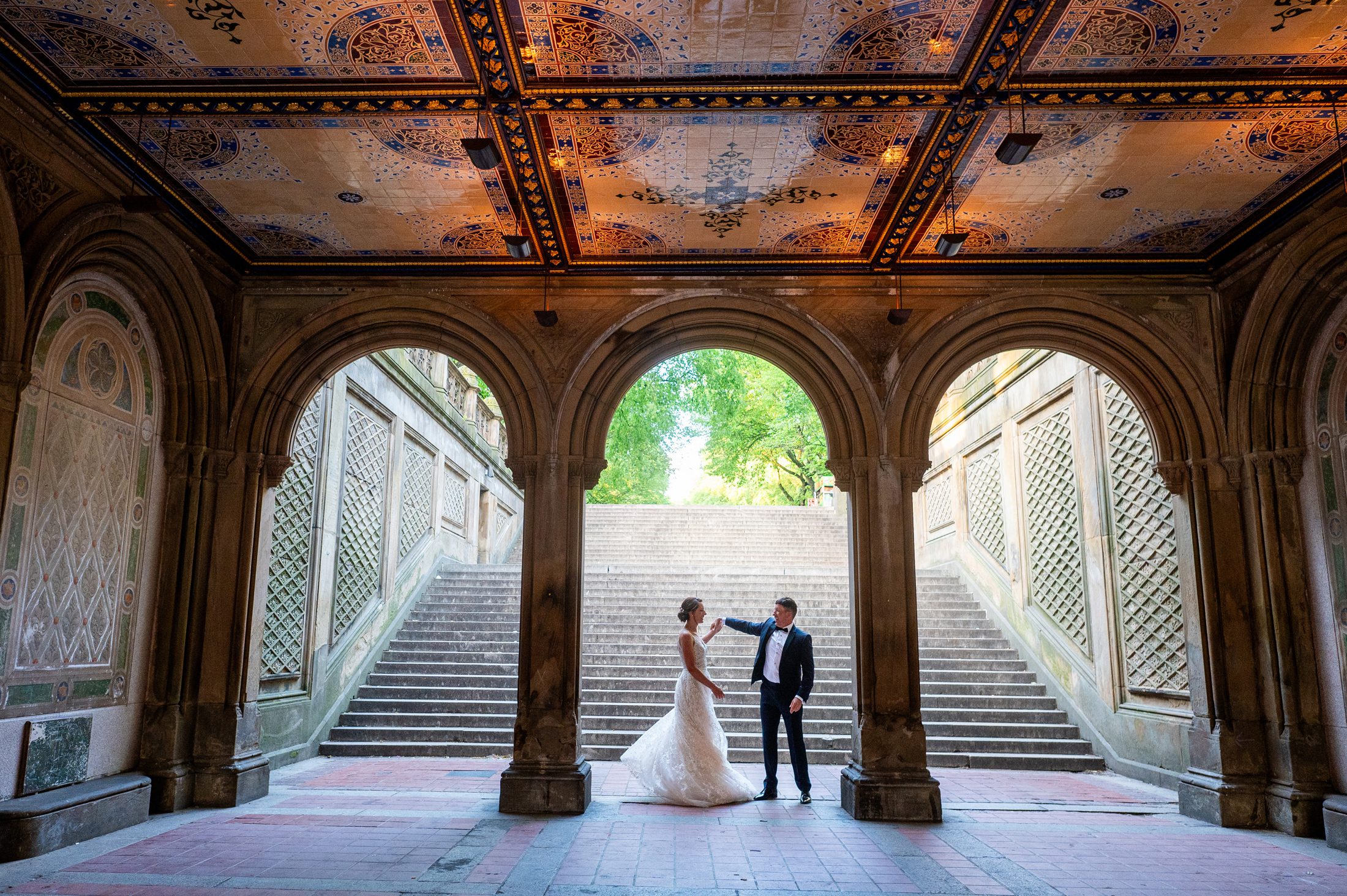 Bride and groom dancing under the arches of Bethesda Terrace after their sunrise elopement in Central Park . 