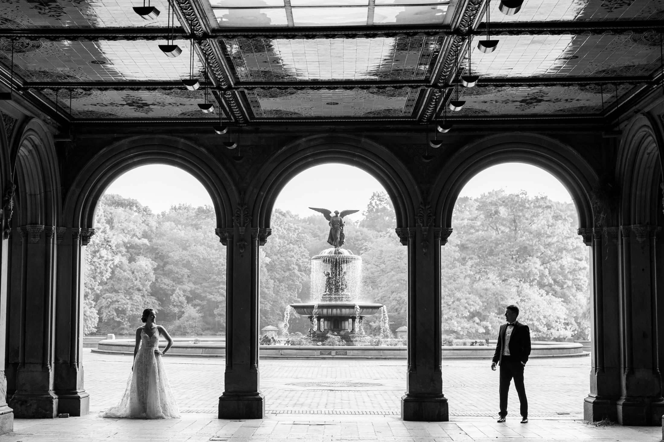 Black and white photo of bride and groom under the arches in Bethesda Terrace 