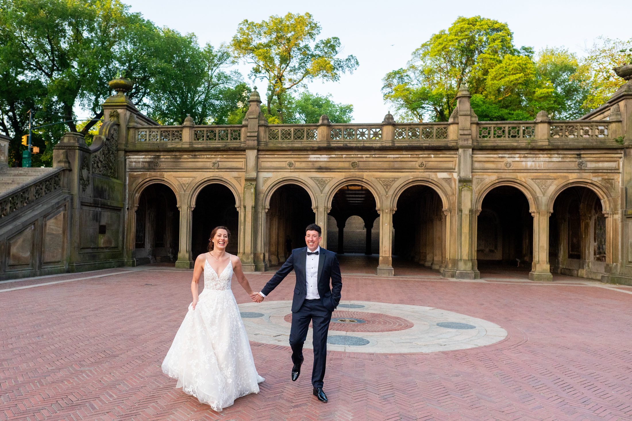 Bride and Groom walking with Bethesda Terrace in the background. 