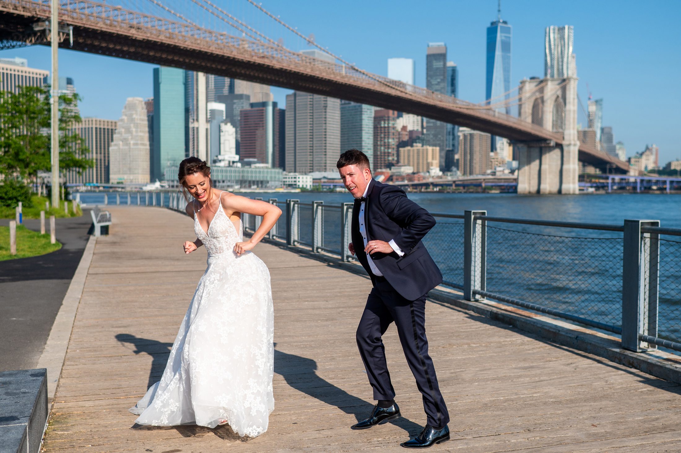Couple dancing with Brooklyn Bridge in the background. 