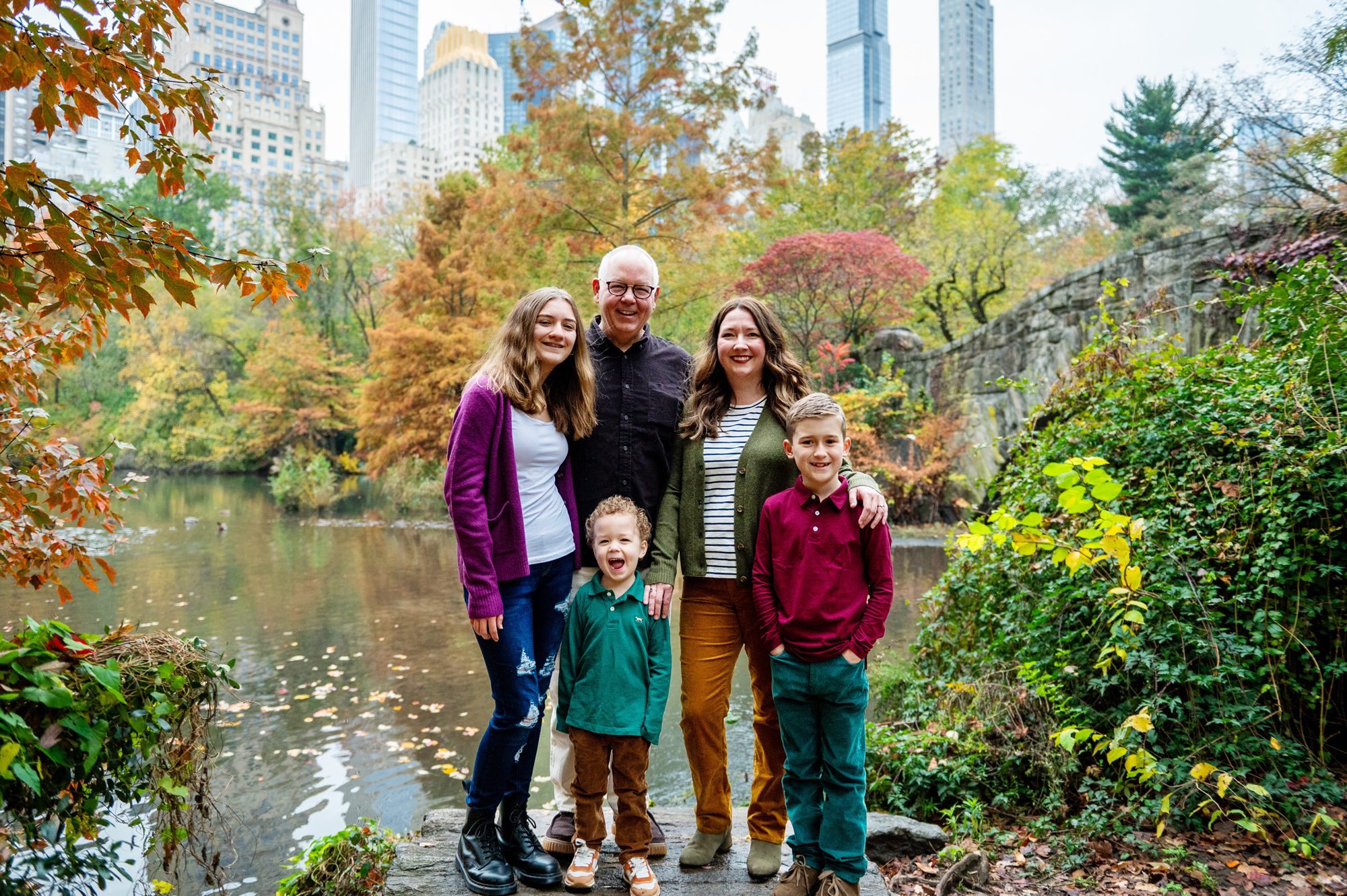 Family being photographed in Central Park in the fall. 