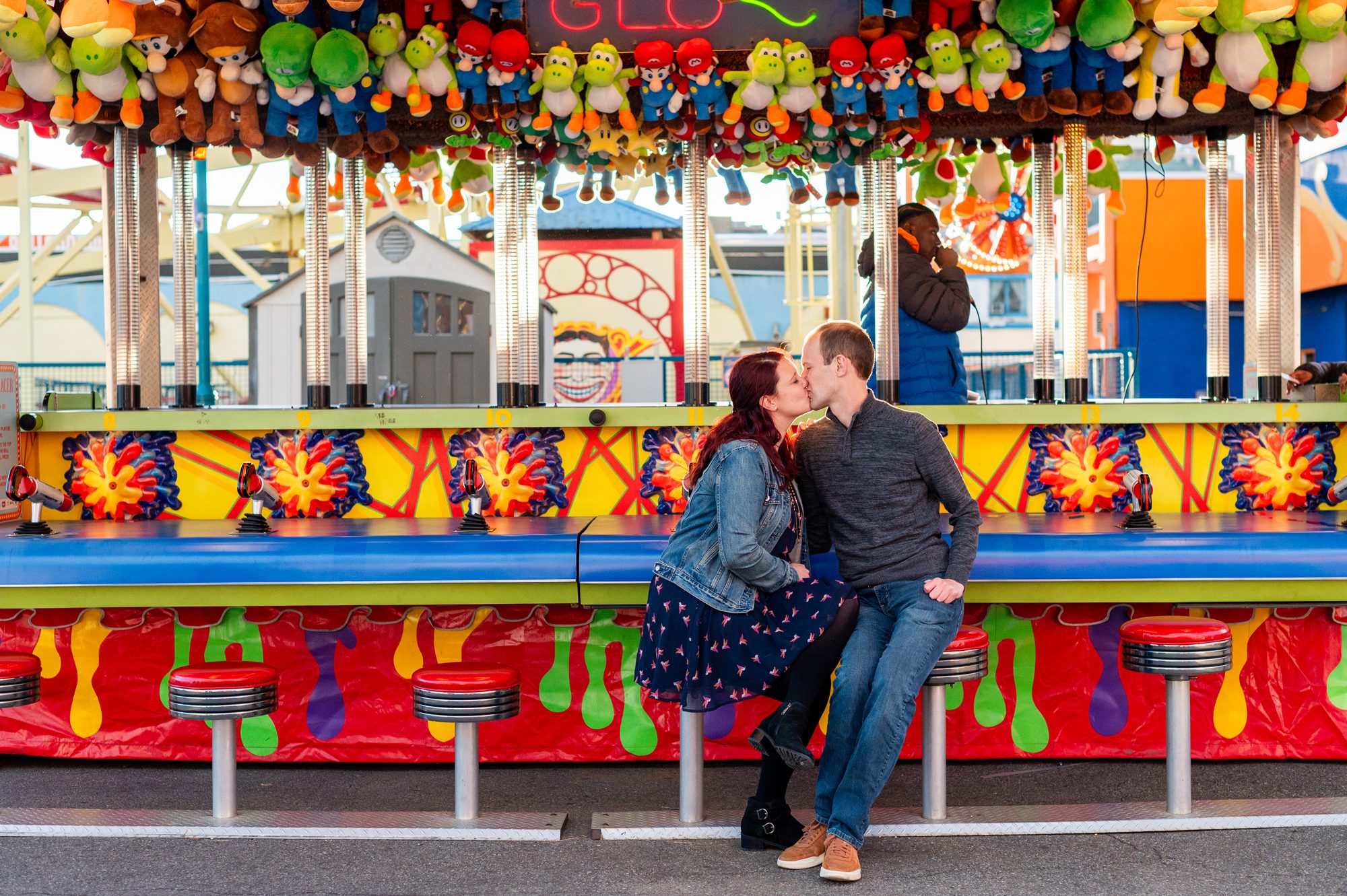 Couple kissing in front of games at Coney Island