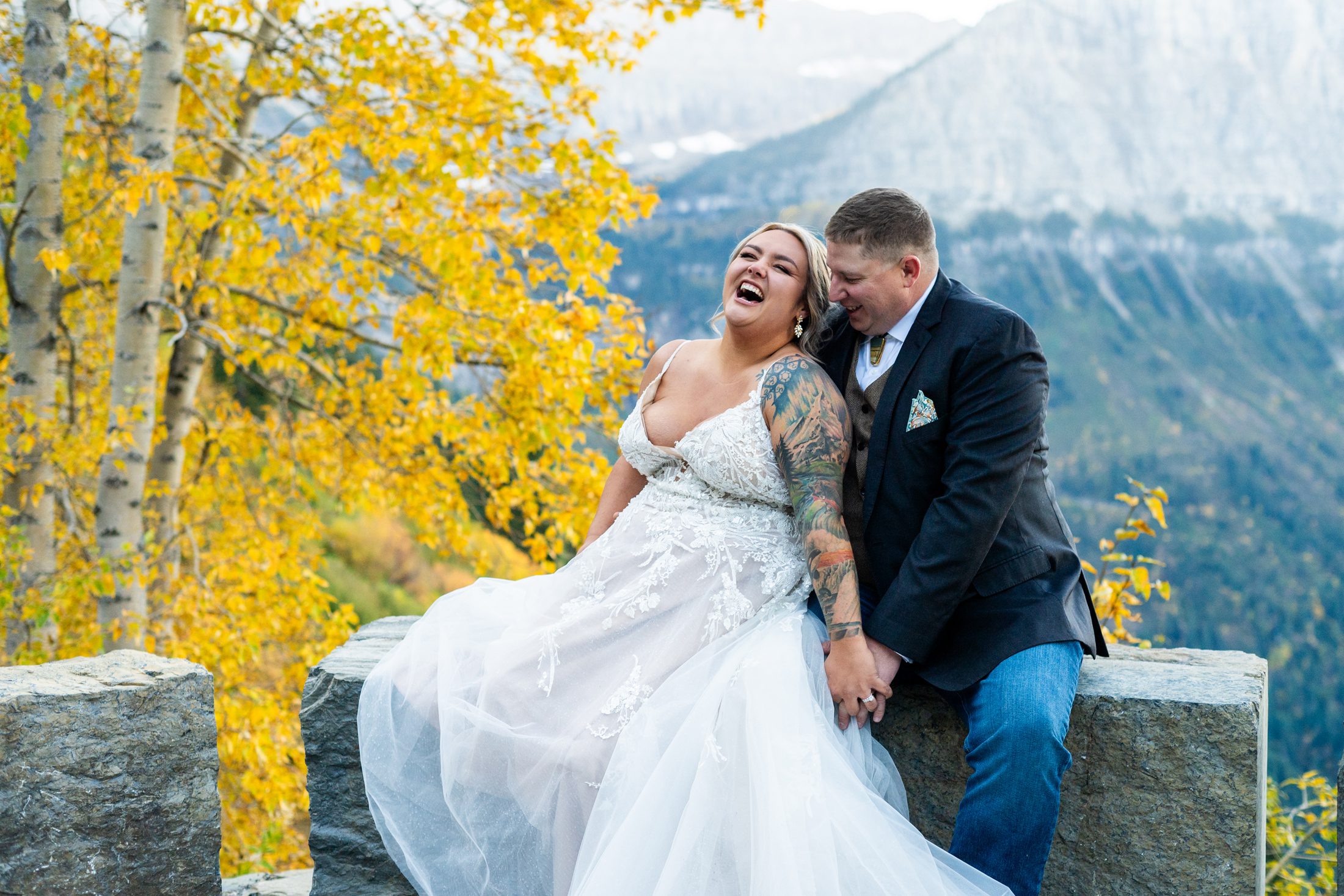 Couple laughing by yellow tree in Glacier National Park