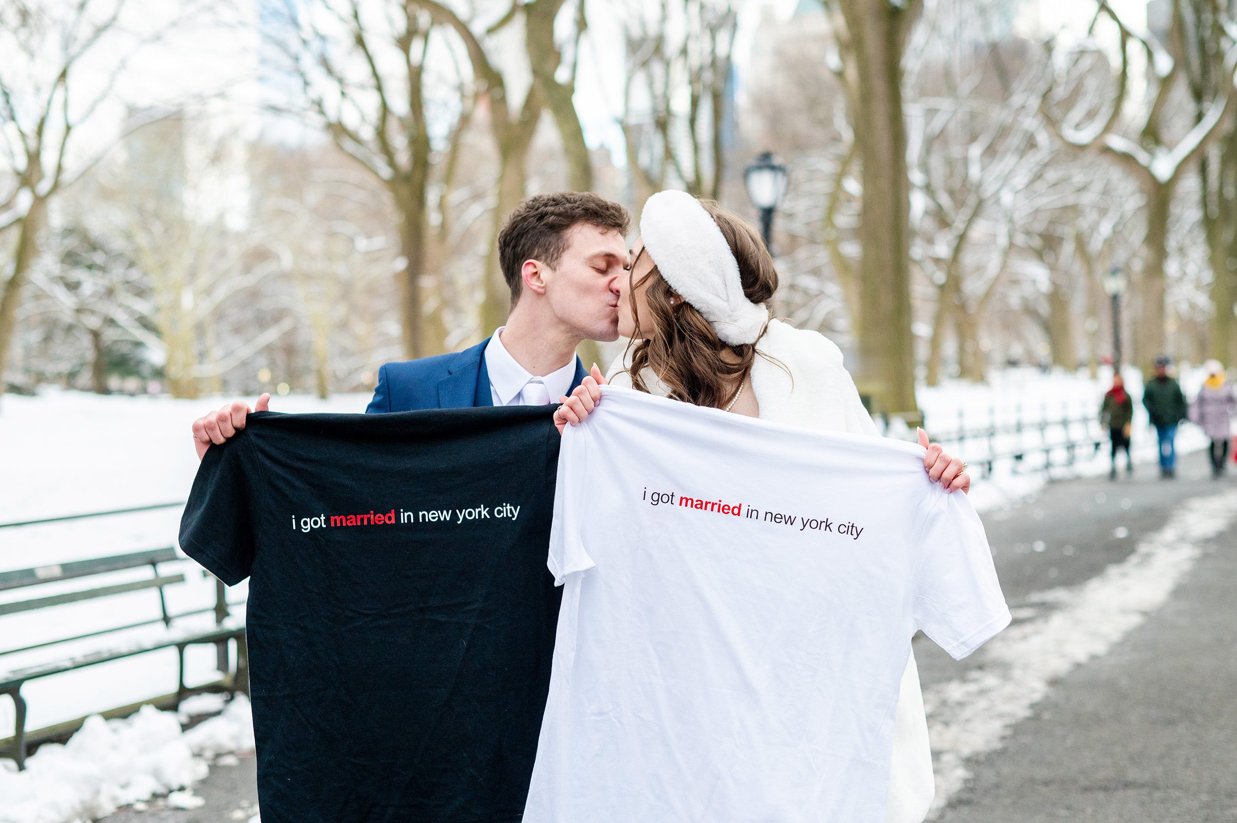Couple holding up I Got Married in NYC TShirts