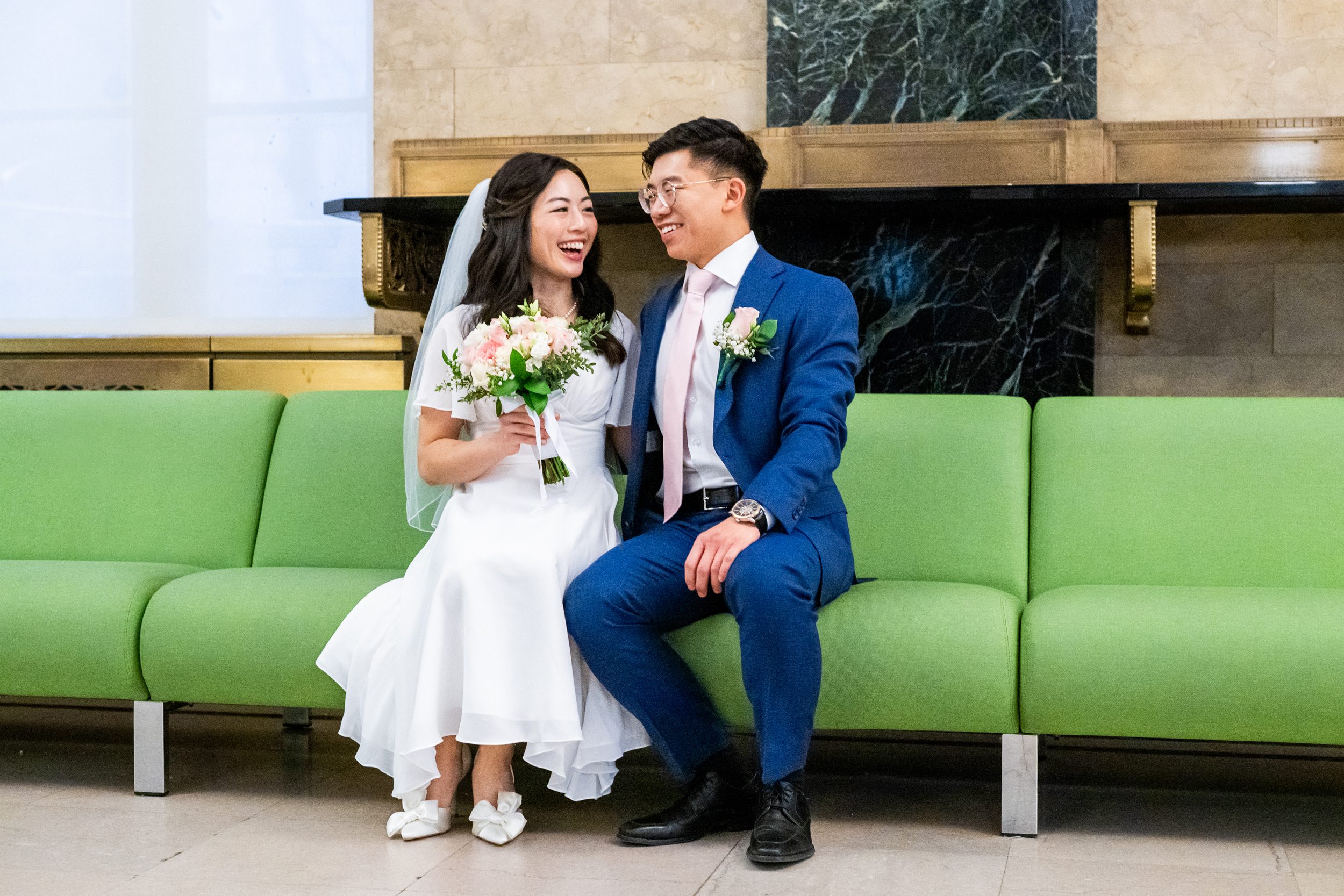 Couple sitting on green couch in NYC City Clerk's Office