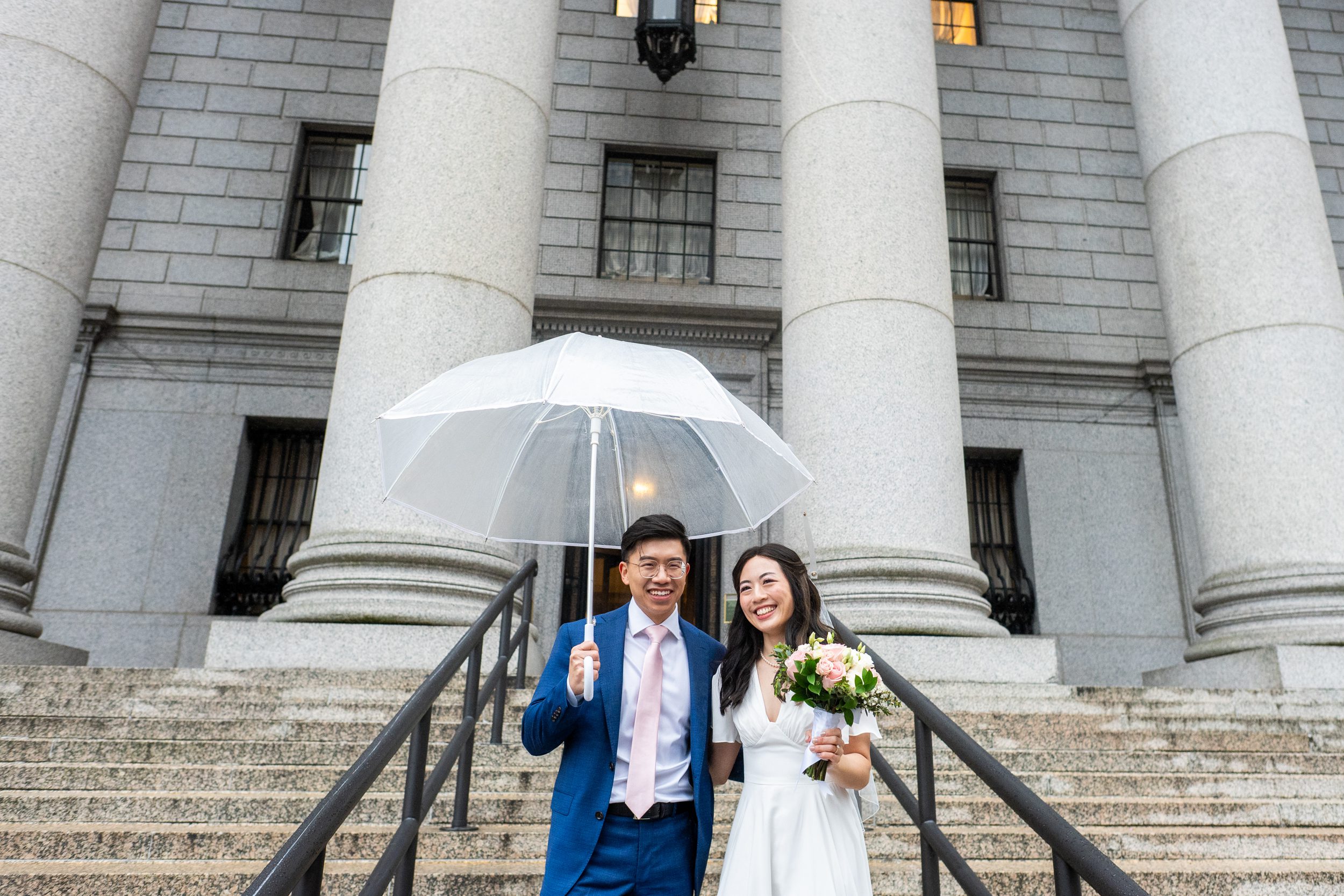 Bride and groom on courthouse steps after city hall wedding in NYC