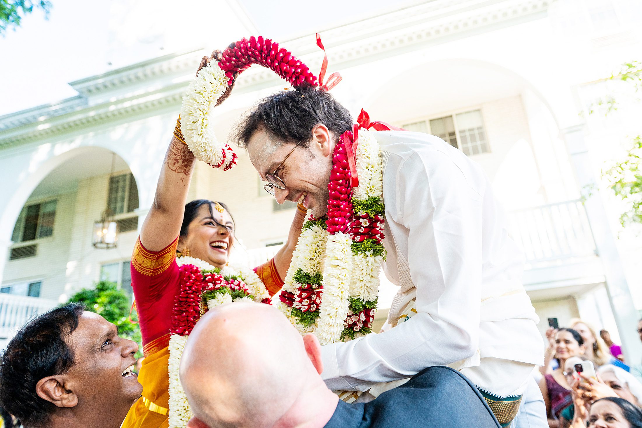 Fun ceremony photos of bride throwing garland on groom at Madison Hotel in New Jersey