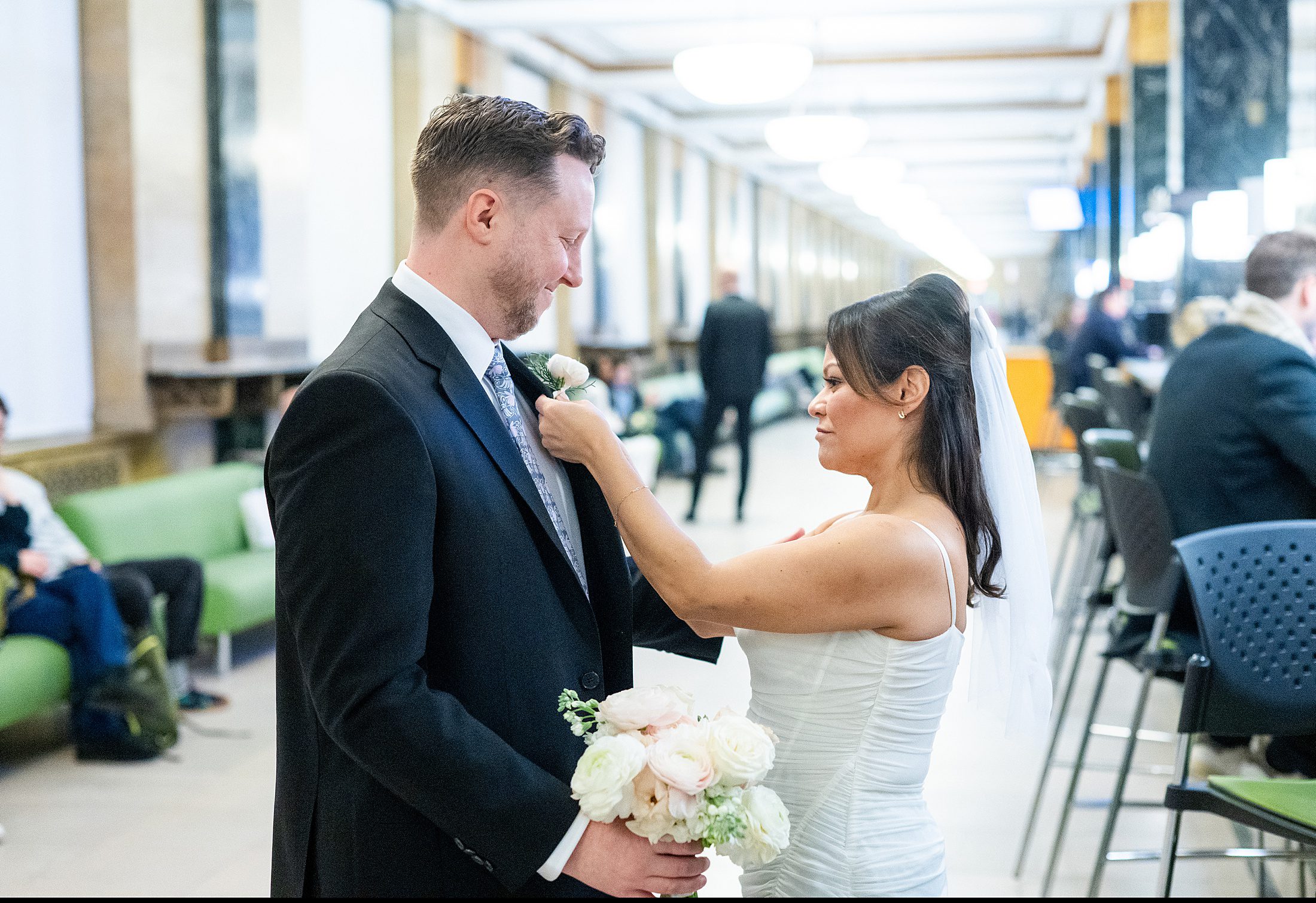 Bride pinning a flower on the groom at a courthouse wedding in Manhattan
