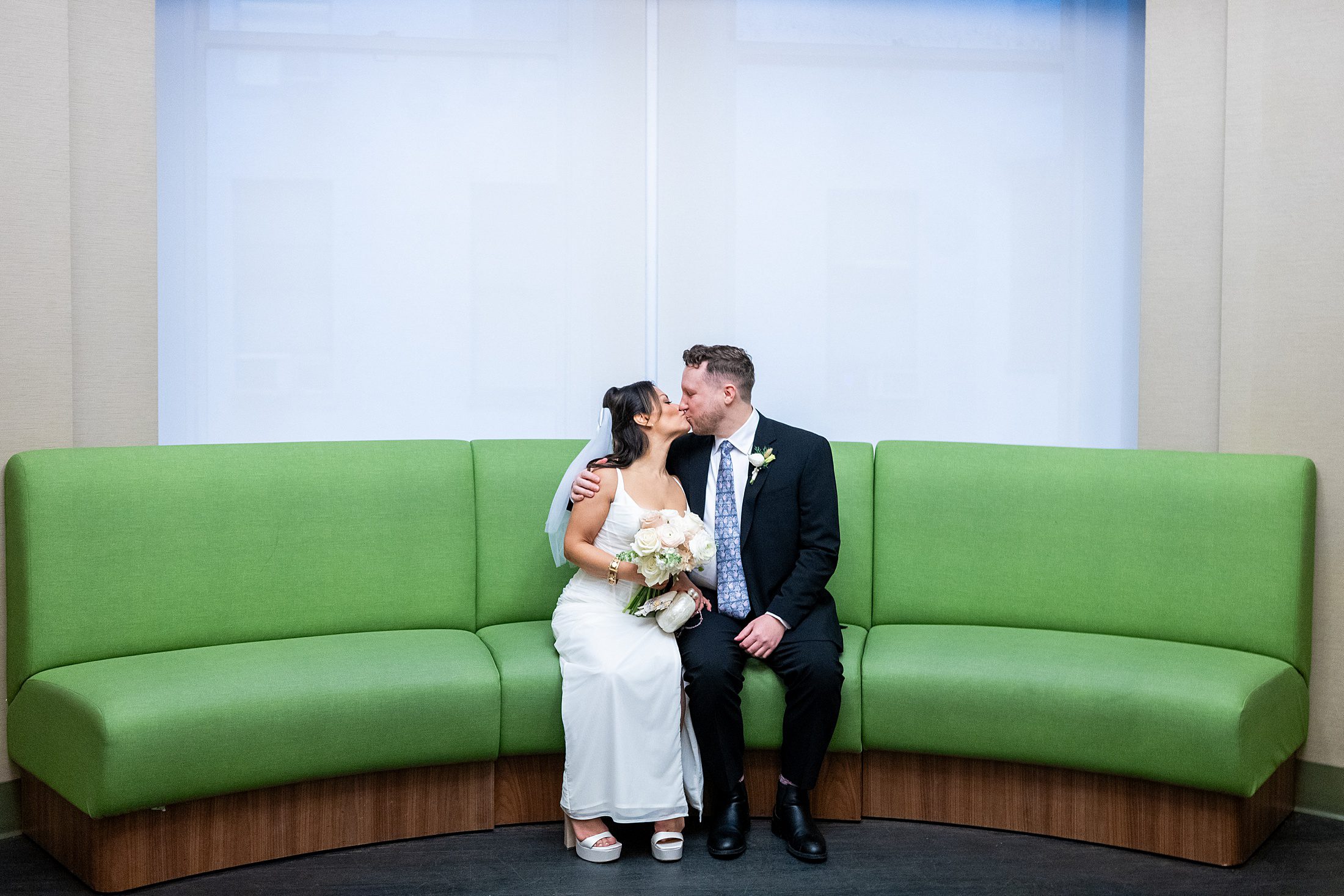 Bride and groom on lime green couch at courthouse wedding in manhattan 