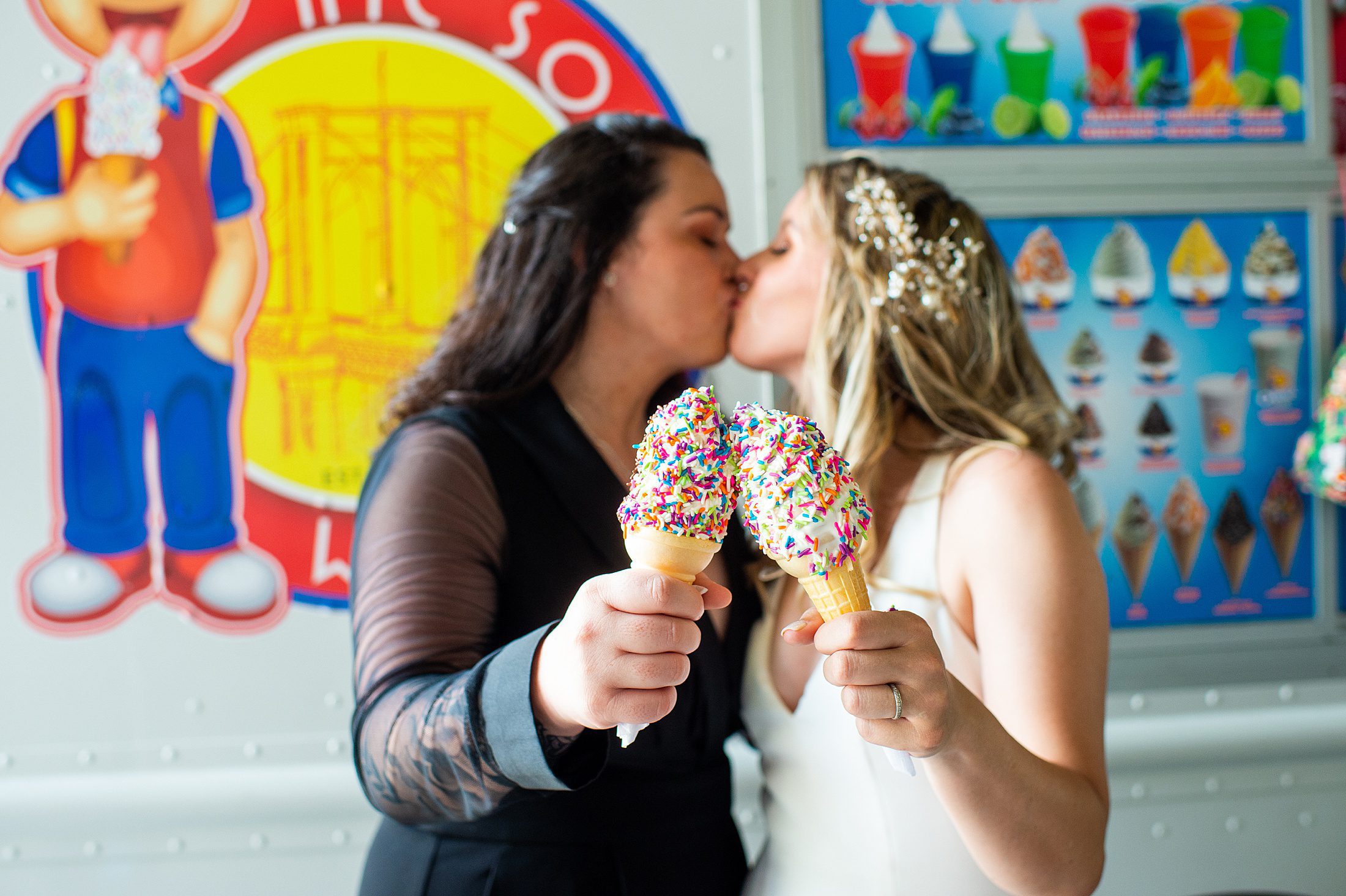Two brides kissing behind an ice cream cone after their summer elopement in Brooklyn 