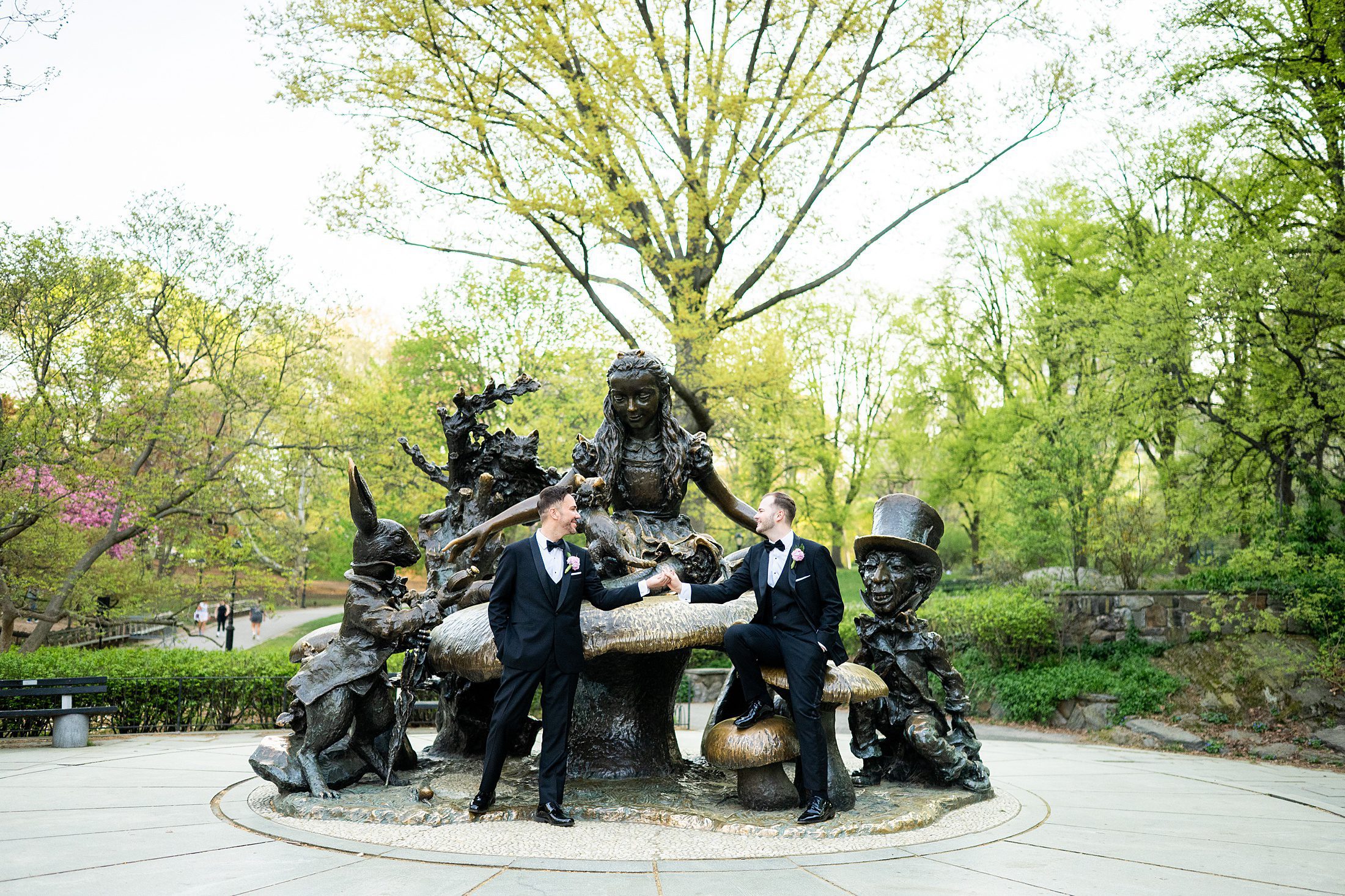 Wedding photo with two grooms in front of the Alice in Wonderland statue in Central Park 